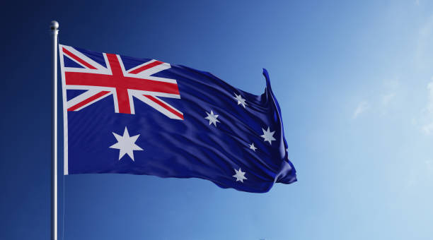 High quality 3d render of an Australian flag waving with wind on a blue sky. Horizontal composition.