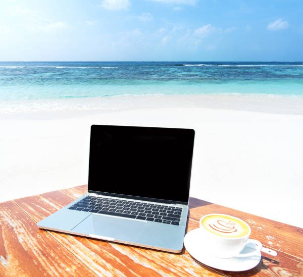 istock Laptop Computer And Coffee Cup On The Table At Seaside 1075798786