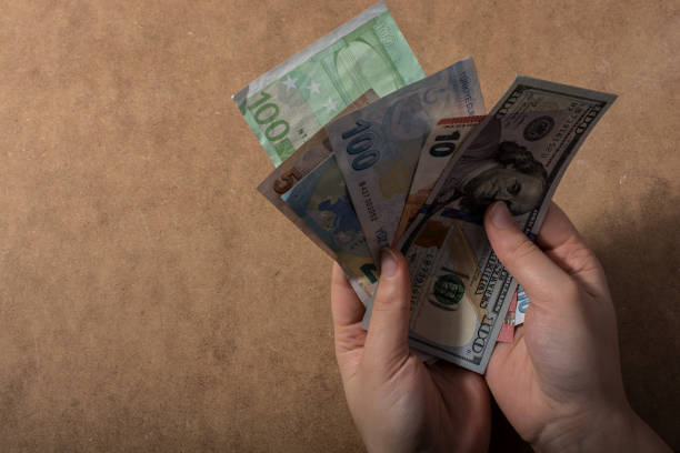 istock Hand holding American dollar  isolated on wooden background 1075857166