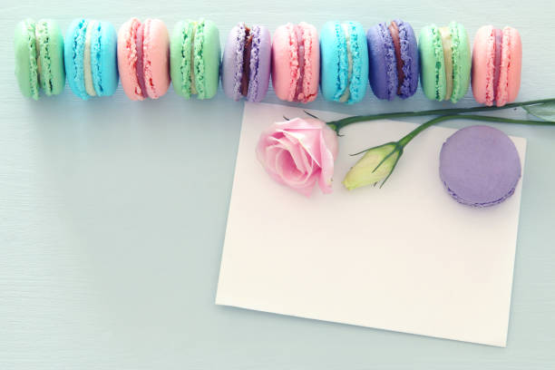 istock top view image of macaroons over wooden table, emprty note and flowers. 1075862096