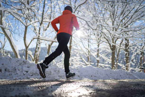 istock endurance training woman jogging alone on road in winter 1075879490