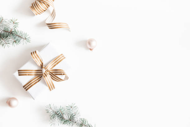 Christmas composition. Gift, fir tree branches, balls on white background. Christmas, winter, new year concept. Flat lay, top view, copy space