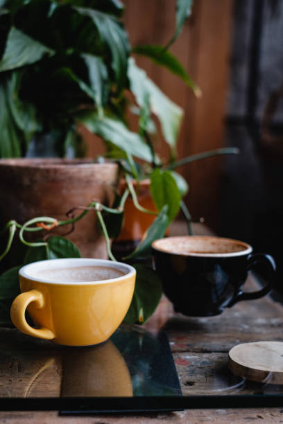 istock Yellow and black cups with coffee on wooden table 1075891728