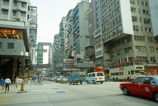 Hong Kong, China, 1978. Street cents in Hong Kong. Furthermore: pedestrians, cars, buildings, traffic and advertising signs.