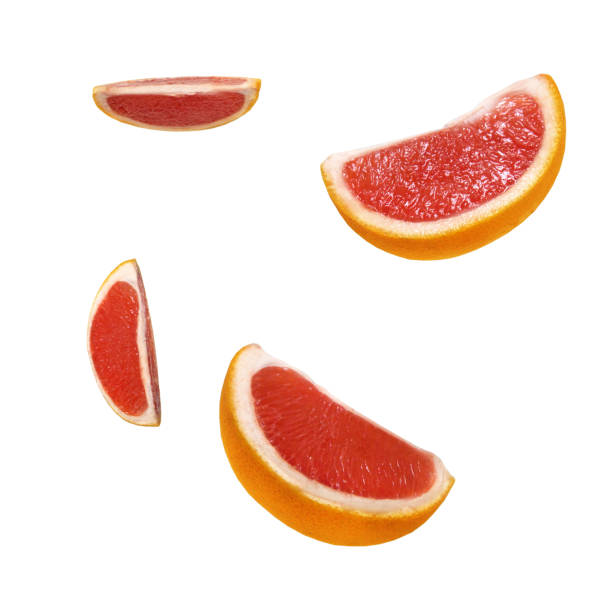 istock Fresh delicious pieces of grapefruit isolated on white background. Creative minimalistic food concept. 1075917754