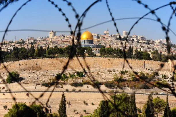View from the Mount of Olives on the dome of the rock and ancient cemetery through the barbed wire, as a symbol of Palestine Israeli conflict