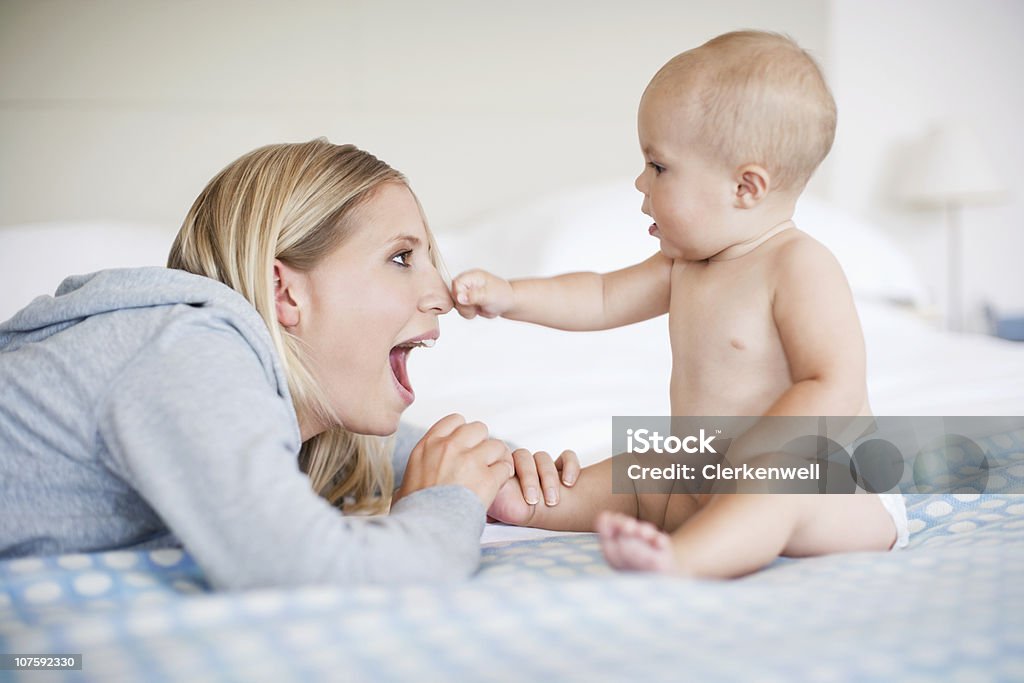 Menino bebê (6 a 11 meses) segurando mãe's nose - Foto de stock de 25-30 Anos royalty-free