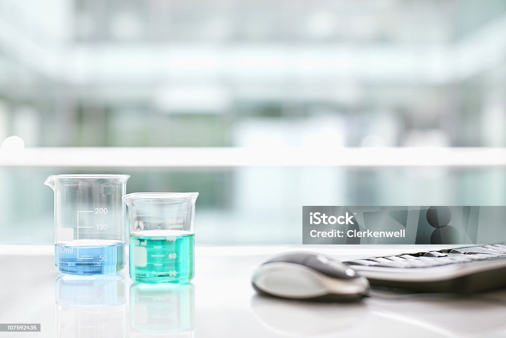 Beakers avec ordinateur de bureau avec la souris et clavier sans fil - Photo de Absence libre de droits