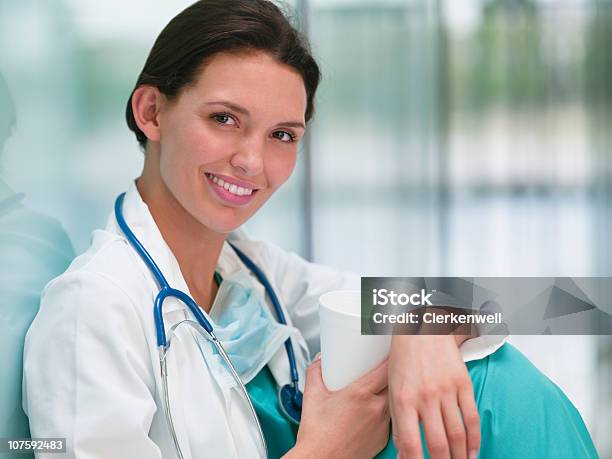 Closeup Of A 웃는 여자 간호사 커피잔을 25-29세에 대한 스톡 사진 및 기타 이미지 - 25-29세, 건강관리와 의술, 근거리 초점