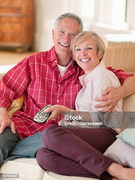 Photo libre de droit de Portrait Dun Couple Souriant Regarder La Télévision banque d'images et plus d'images libres de droit de 55-59 ans