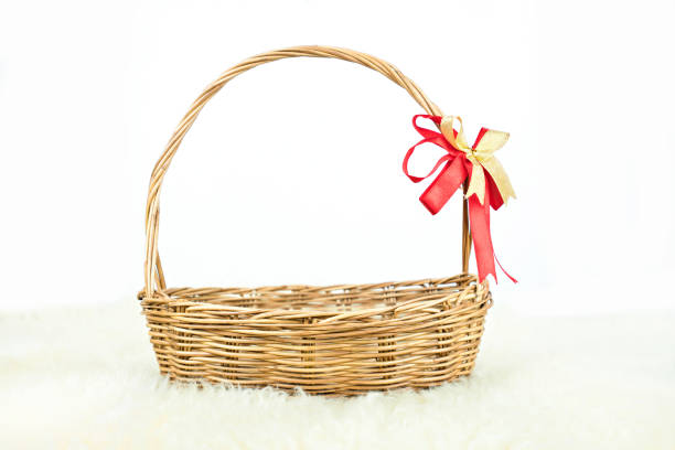 istock Empty wicker basket with red and gold ribbon isolated on white background 1075926132