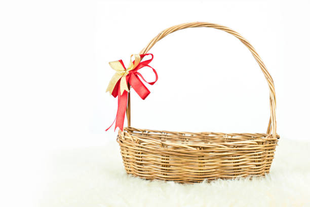 istock Empty wicker basket with red and gold ribbon isolated on white background 1075926136