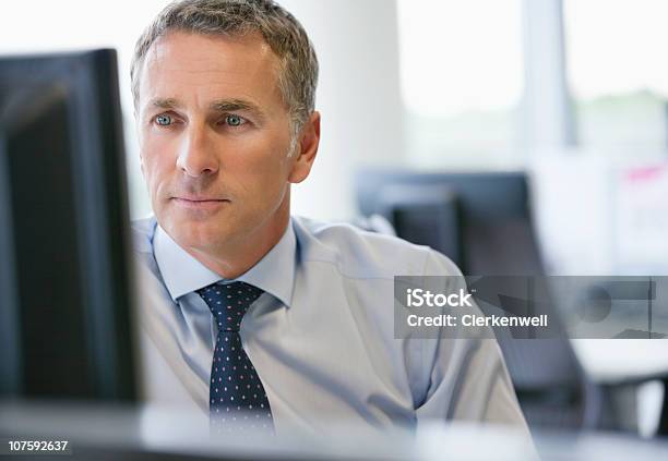 Mature Business Executive Looking At Computer Screen At Office Stock Photo - Download Image Now