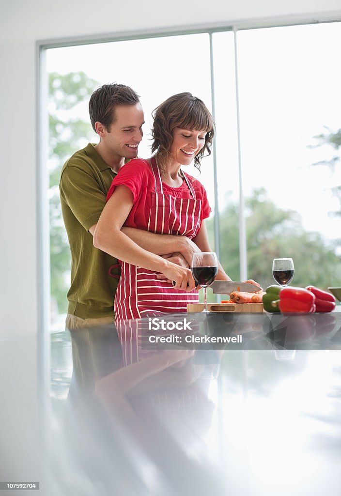Junger Mann umarmt Frau, während Sie die Zubereitung von Speisen in der Küche - Lizenzfrei 25-29 Jahre Stock-Foto