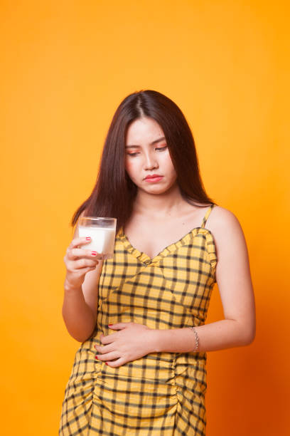 asiatique femme buvant un verre de lait obtenu des maux d’estomac. - got milk photos et images de collection