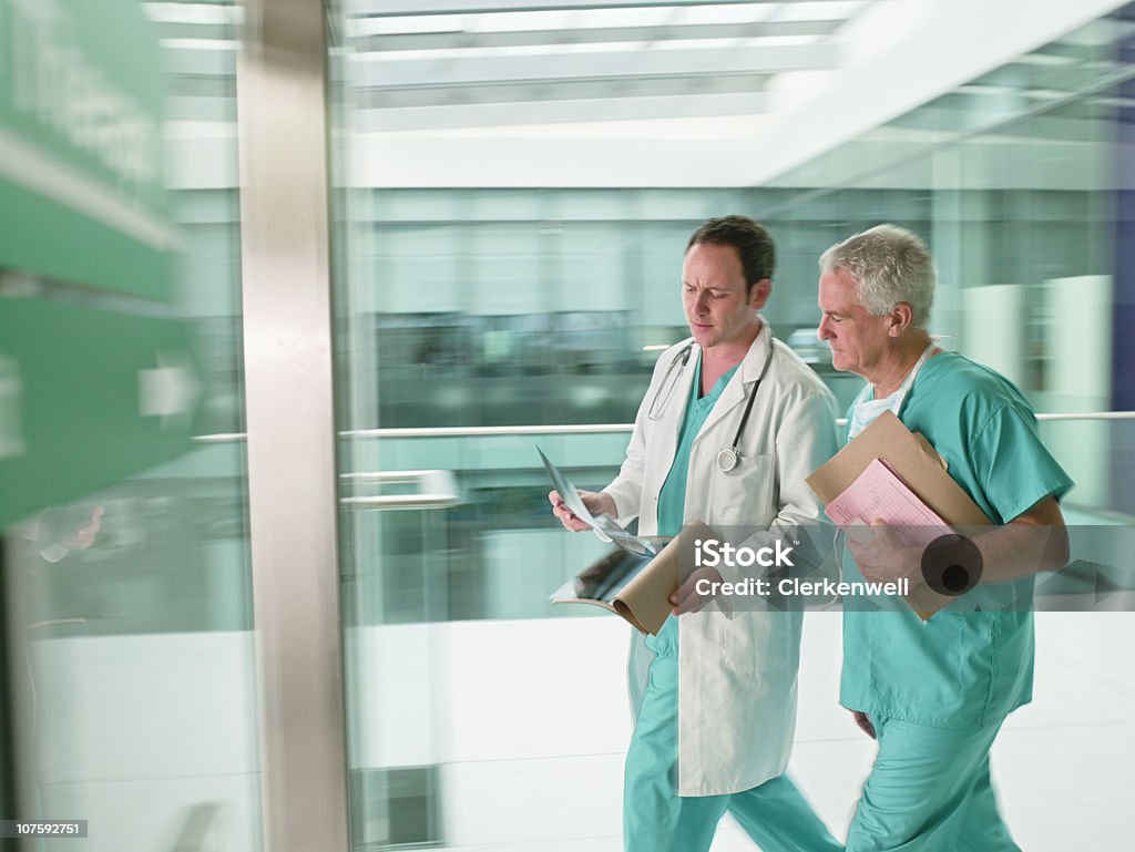 Zwei Ärzte mit Peelings zu Fuß in Eile in hospital - Lizenzfrei 30-34 Jahre Stock-Foto