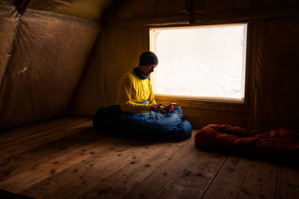 traveler, man rests in the old mountain hut, - home interior cabin shack european alps imagens e fotografias de stock