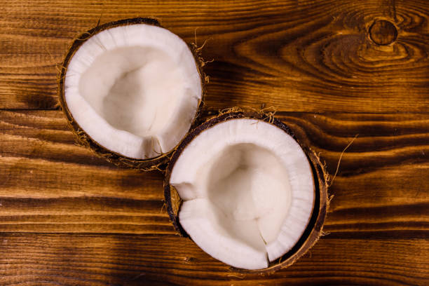 istock Ripe halved coconut on a wooden table. Top view 1075932292