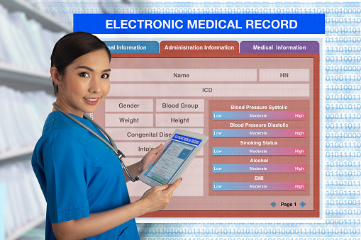 Female doctor holding tablet that showing medical record form in hands with blank electronic medical record form on background.
