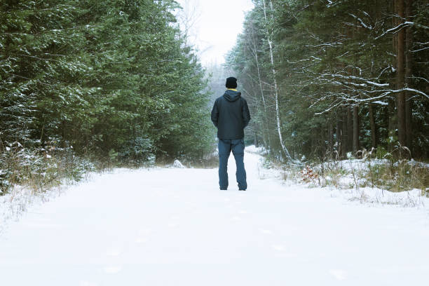 istock Young man standing in winter landscape in forest 1075955878