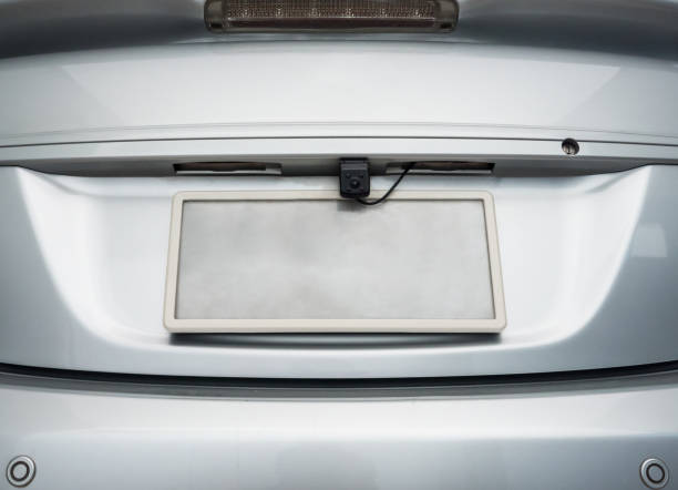 Rear view camera. Rear view camera is hidden on the license plate behind the sedan car. looking in mirror stock pictures, royalty-free photos & images