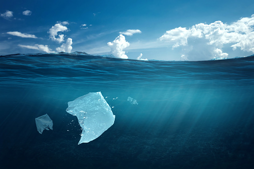 Creative background, plastic bag floating in the ocean, a bag in the water. The concept of environmental pollution, non-decomposable plastic, increased debris in the world's oceans.