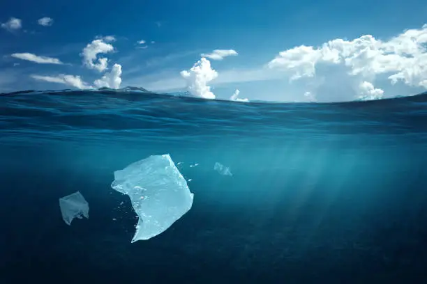 Photo of Creative background, plastic bag floating in the ocean, a bag in the water. The concept of environmental pollution, non-decomposable plastic, increased debris in the world's oceans. copy space