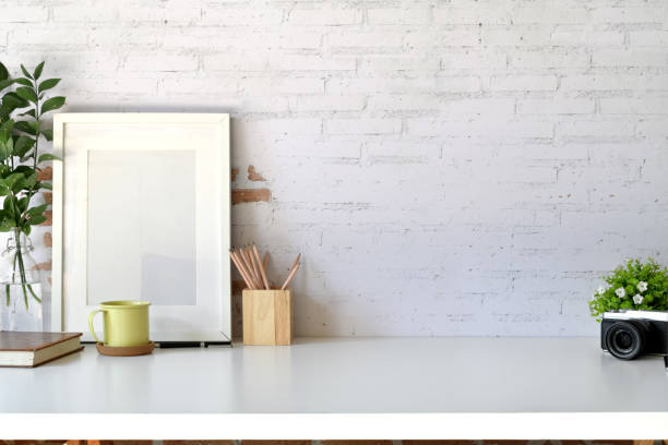 istock Mockup poster template with vintage camera, supplies on white desk workspace and copy space 1075965490