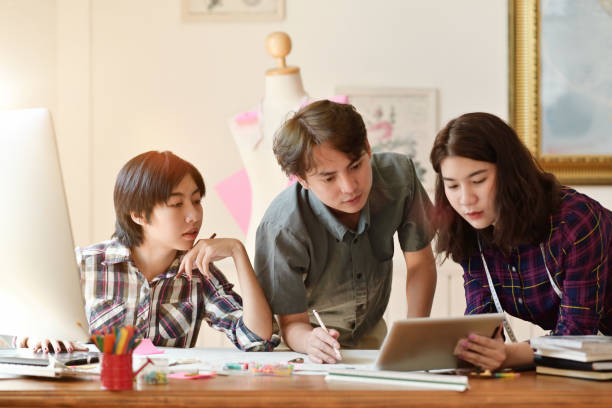 istock Three fashion designers working together in atelier. 1075972614