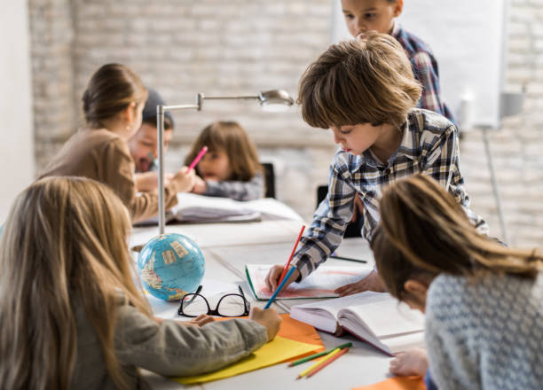 istock Little creative boy drawing in the office with his friends. 1075977202