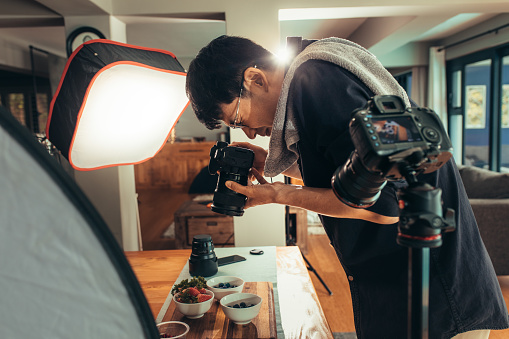 Photographer making vlog on food photography. in studio. Food photographer shooting food and recording video on camera.