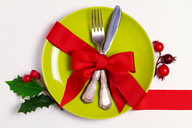 Overhead shot of place setting with Christmas ball on red background.