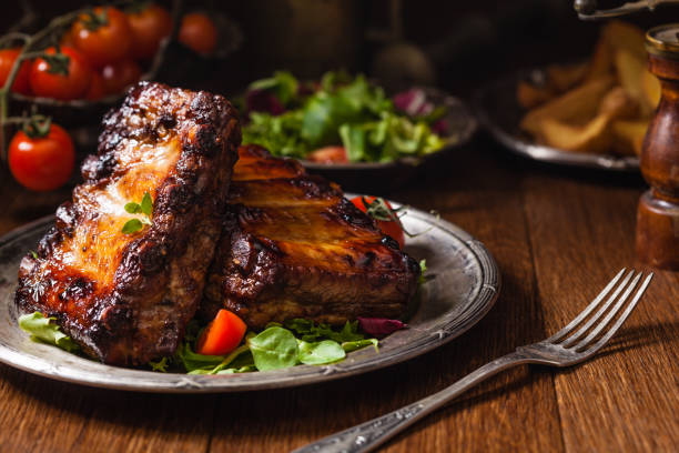 istock Roasted ribs, served on an old plate. Dark or balck background. 1075998412