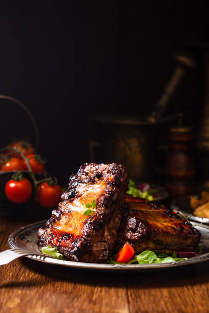 istock Roasted ribs, served on an old plate. Dark or balck background. 1075998428