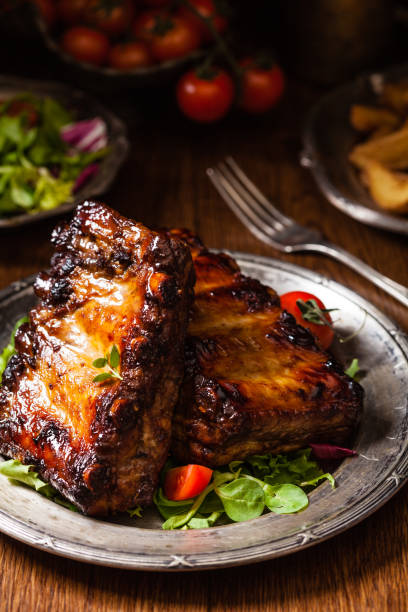 istock Roasted ribs, served on an old plate. Dark or balck background. 1075998456