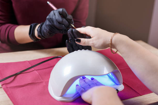 istock painting and drying nails in UV lamp dryer 1076005028