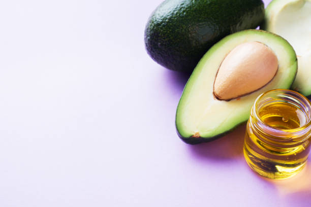 istock Avocado and avocado oil on pink background with copy space. 1076006610