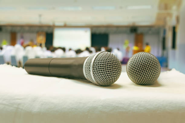 istock Close up old microphone wireless two on the white table in business conference interior seminar meeting room 1076016788