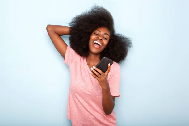istock happy young african american woman looking at cellphone text message 1076016806