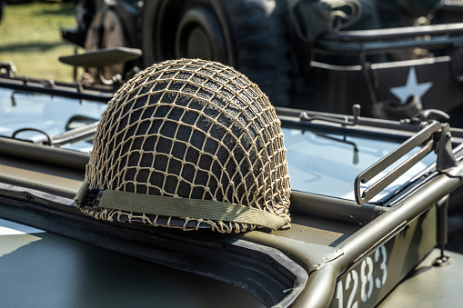 Green military helmet with net on a vehicle