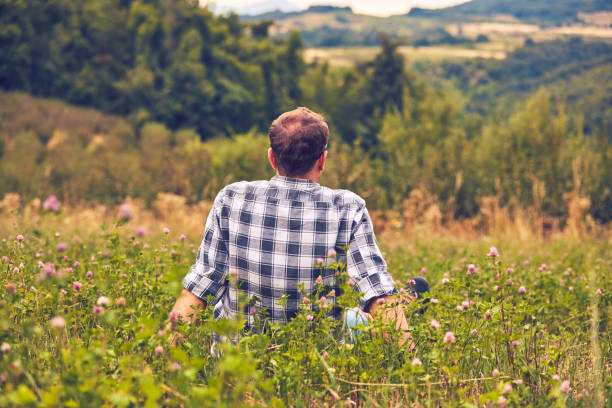 istock Man taking a break in nature and looking at the distant landscape. 1076018840