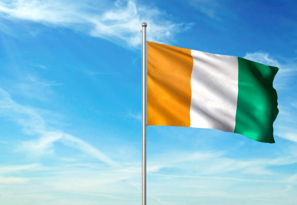 istock Cote dIvoire Ivory coast flag waving cloudy sky background realistic 1076022406