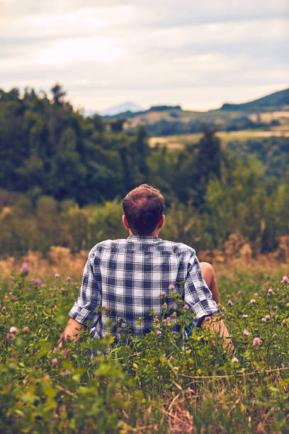 istock Man taking a break in nature and looking at the distant landscape. 1076024046