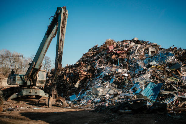 istock Recycling station. Metal dump with working crane and deep blue sky 1076028328