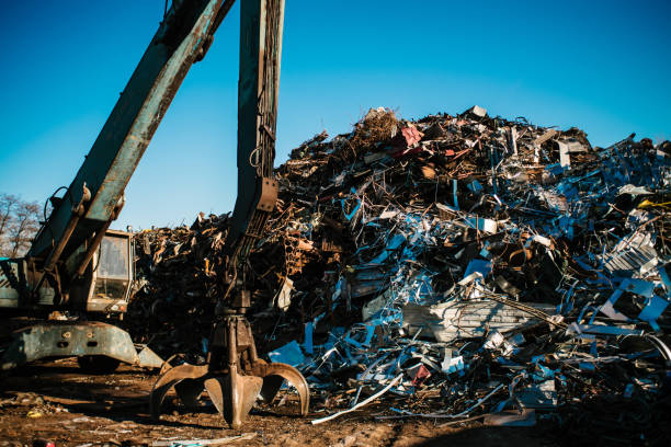 istock Recycling station. Metal dump with working crane and deep blue sky 1076028450