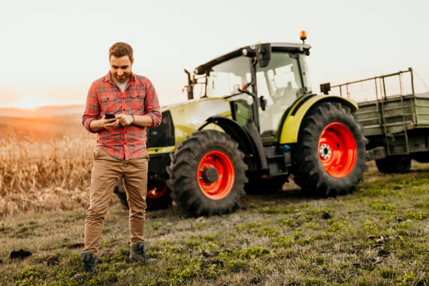istock Male farmer working on field using smartphone in modern agriculture 1076028766