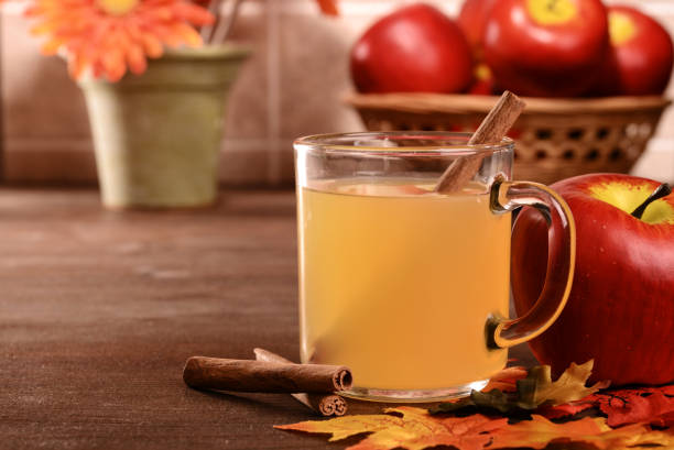 closeup mug of apple cider with cinnamon stick closeup mug of apple cider with cinnamon stick with fall leaves apple juice photos stock pictures, royalty-free photos & images
