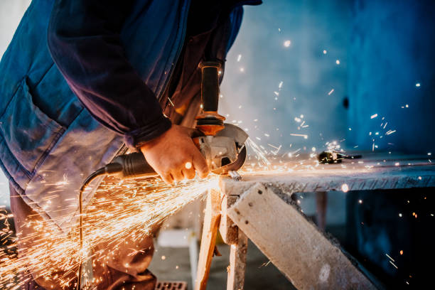istock Metalworker cutting iron and metal with a rotary angle grinder and working 1076040534