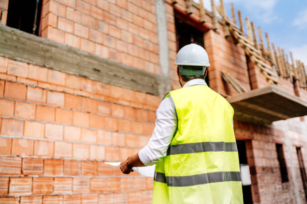 istock man wearing safety vest, hard top on construction site 1076046558