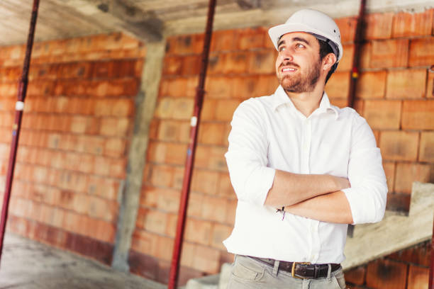 istock Portrait of engineer working on construction site, smiling and working 1076046580